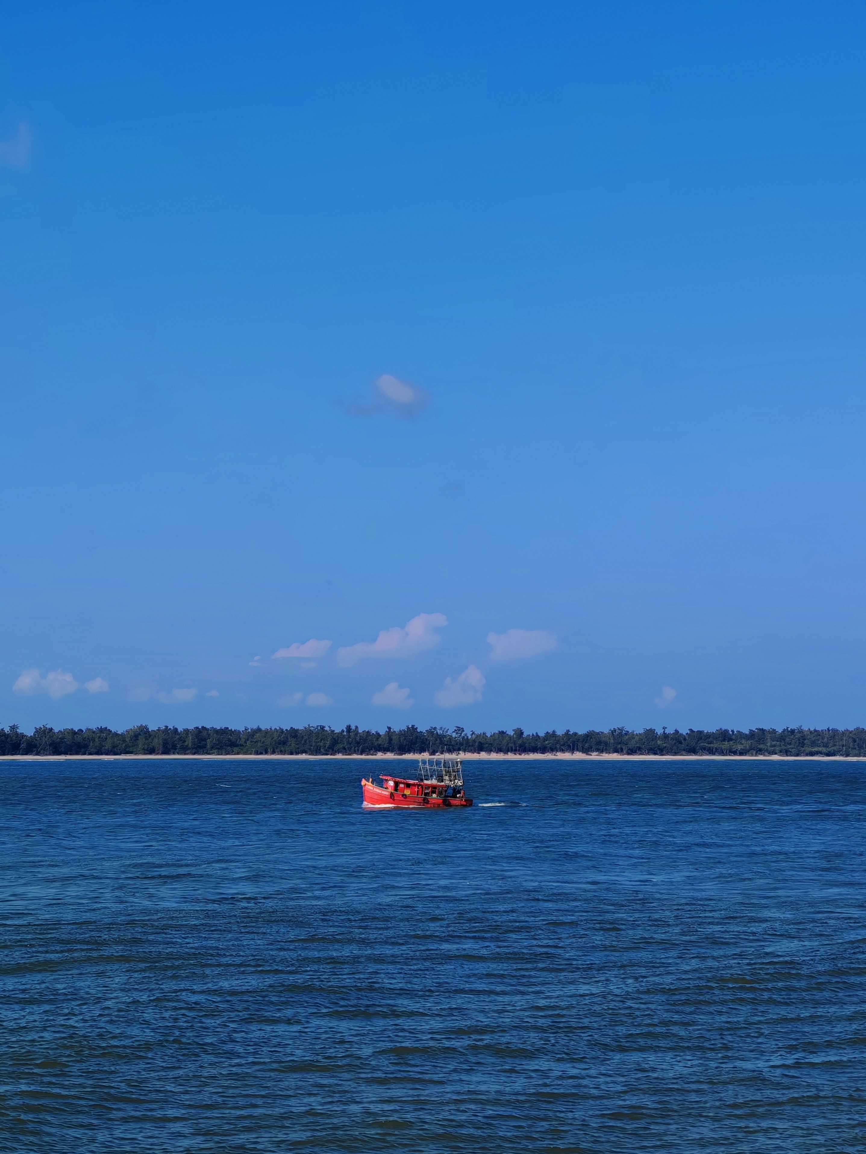 A red fishing boat on deep blue water